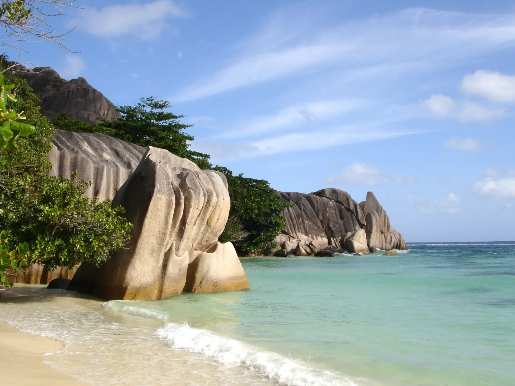 Glad geschuurde granietrotsen van La Digue halverwege het water bij Anse Source d'Argent, Seychellen